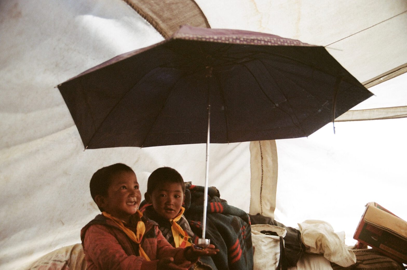 boy holding umbrella in tent